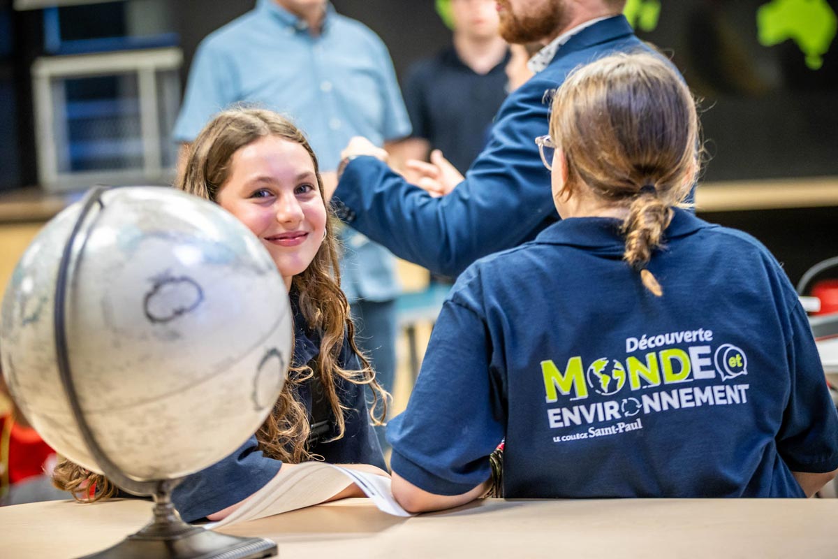 Deux élèves devant un globe terrestre dans la classe de la Découverte-Monde et environnement